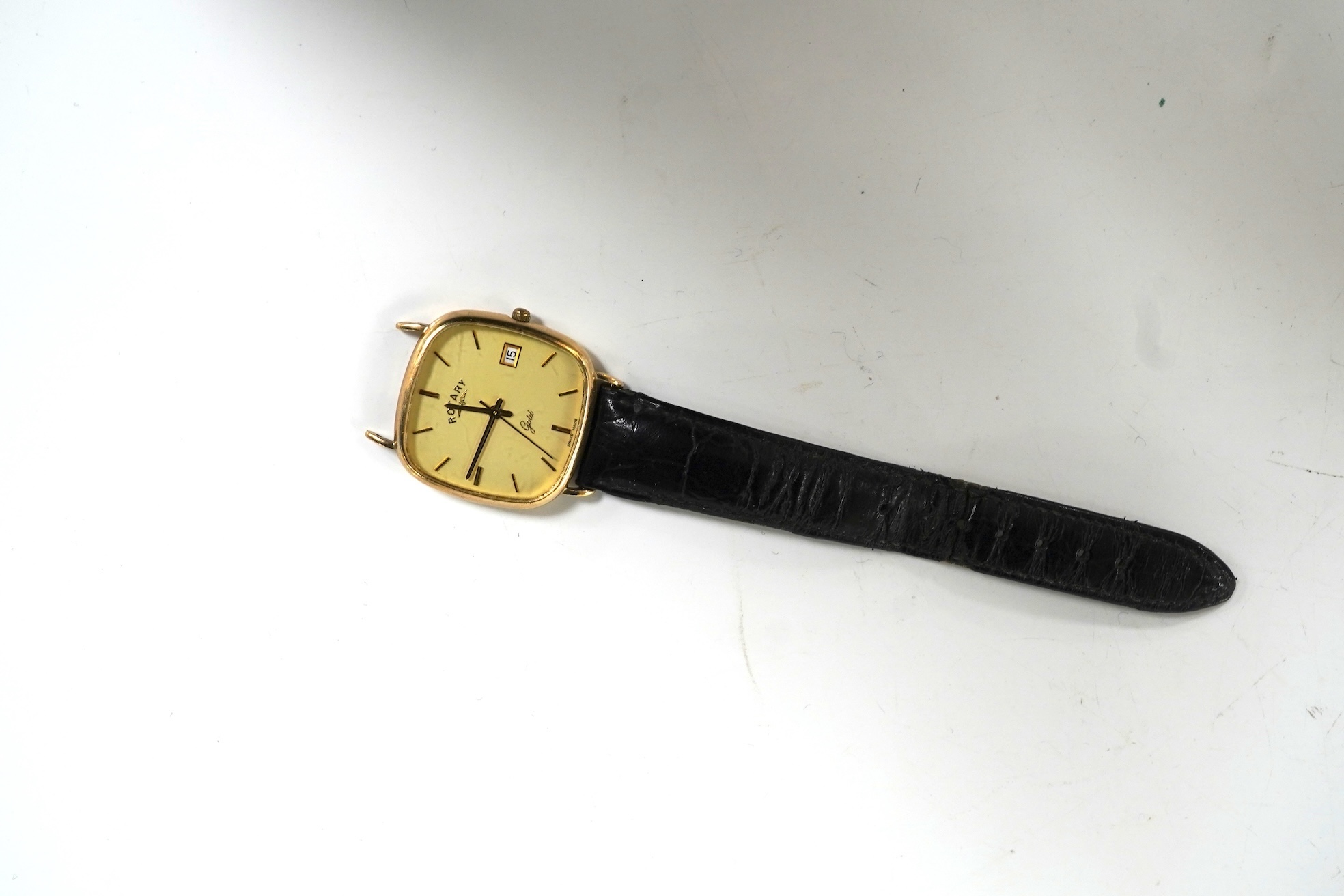 A gentleman's recent 9ct gold Rotary quartz wristwatch, with shaped square dial, baton numerals and date aperture, case diameter 30mm, part of associated leather strap missing.